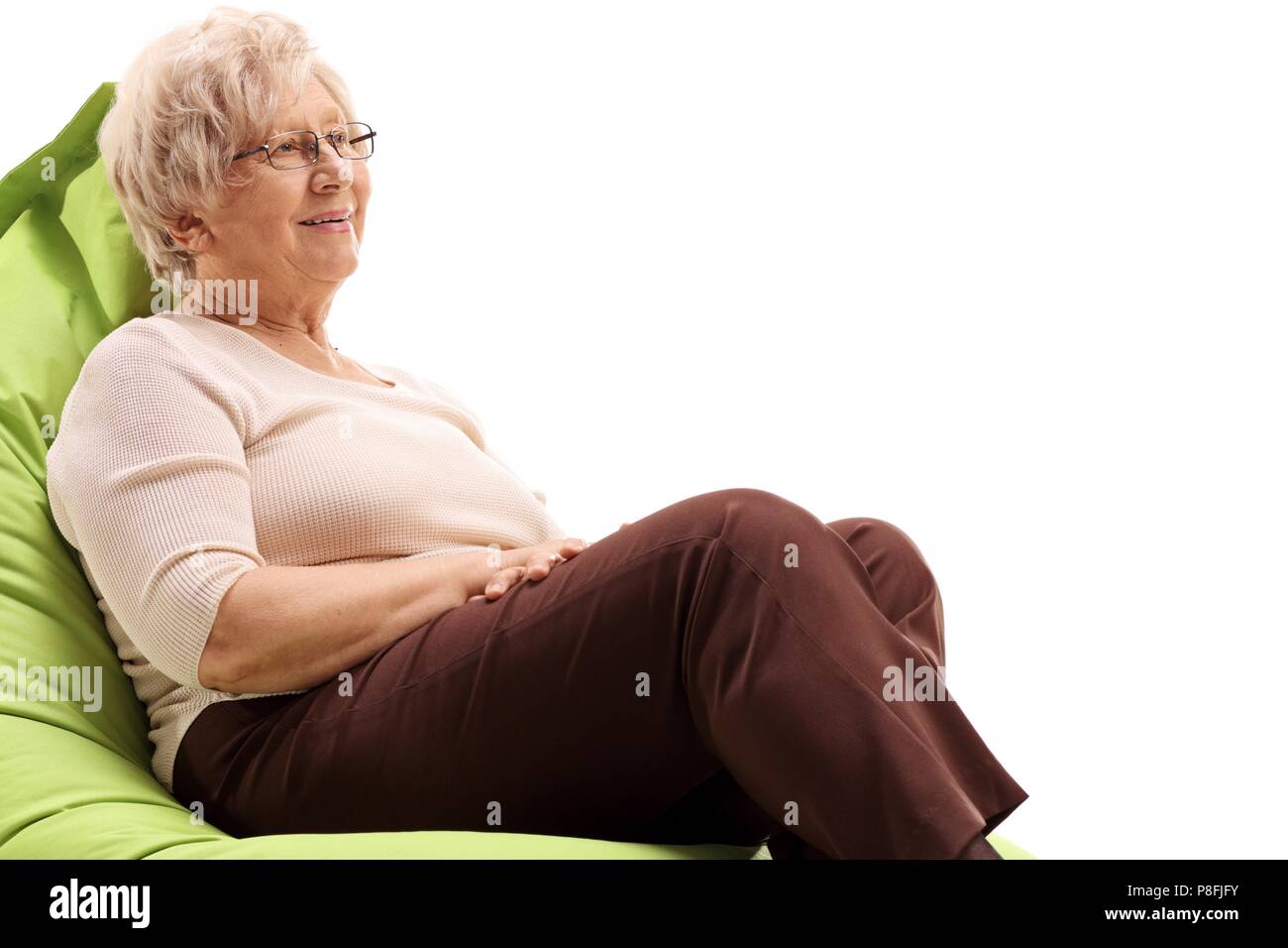 Donna anziana seduta su una beanbag isolati su sfondo bianco Foto Stock
