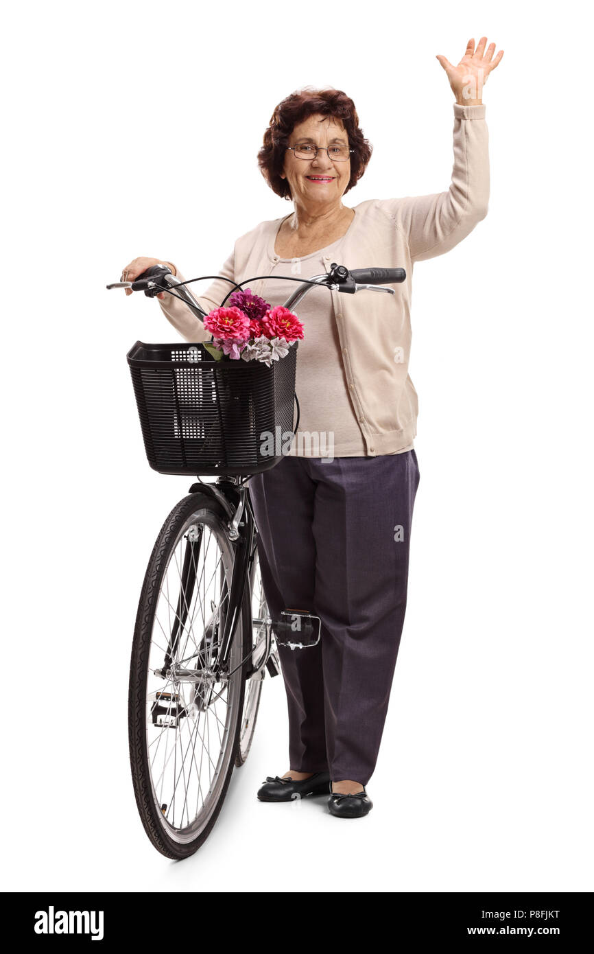 A piena lunghezza Ritratto di una donna anziana con una bicicletta sventolando la fotocamera a isolati su sfondo bianco Foto Stock