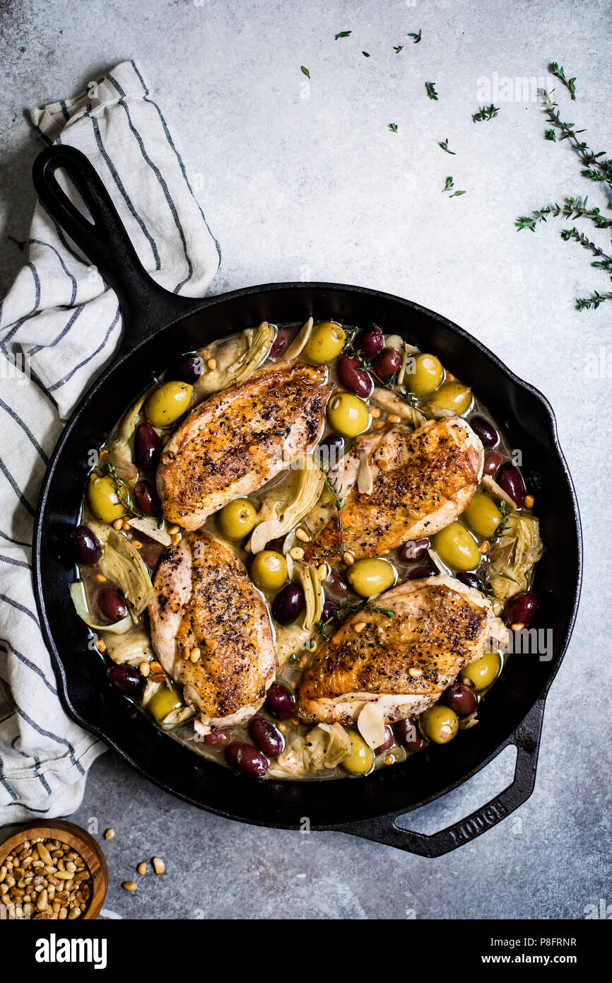 Aglio bianco padella Vino di pollo con olive e carciofi Foto stock - Alamy