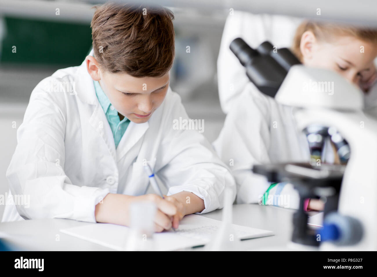 I ragazzi che studiano la chimica in laboratorio scolastico Foto Stock
