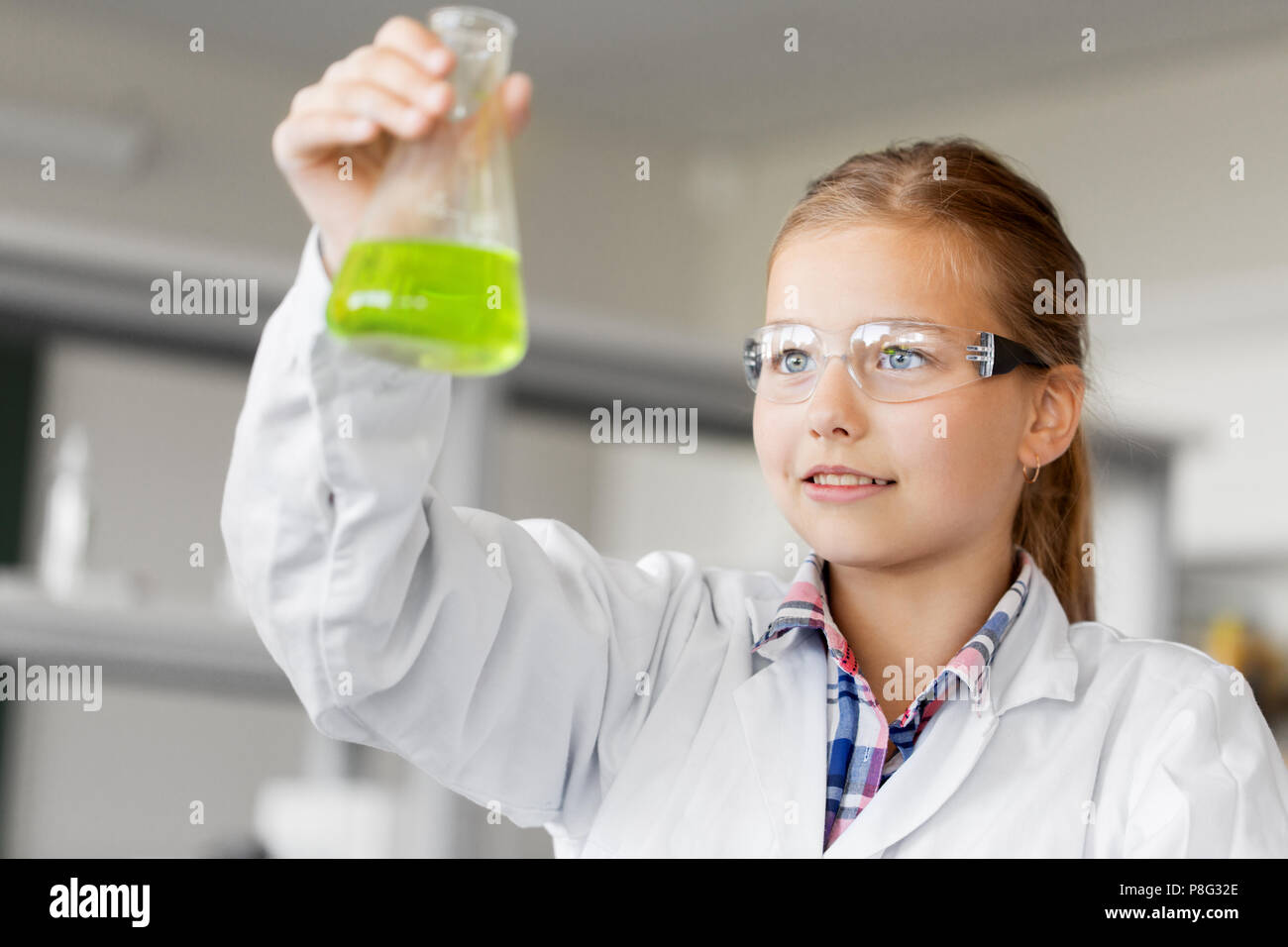 Ragazza con tubo di prova che studia chimica a scuola Foto Stock