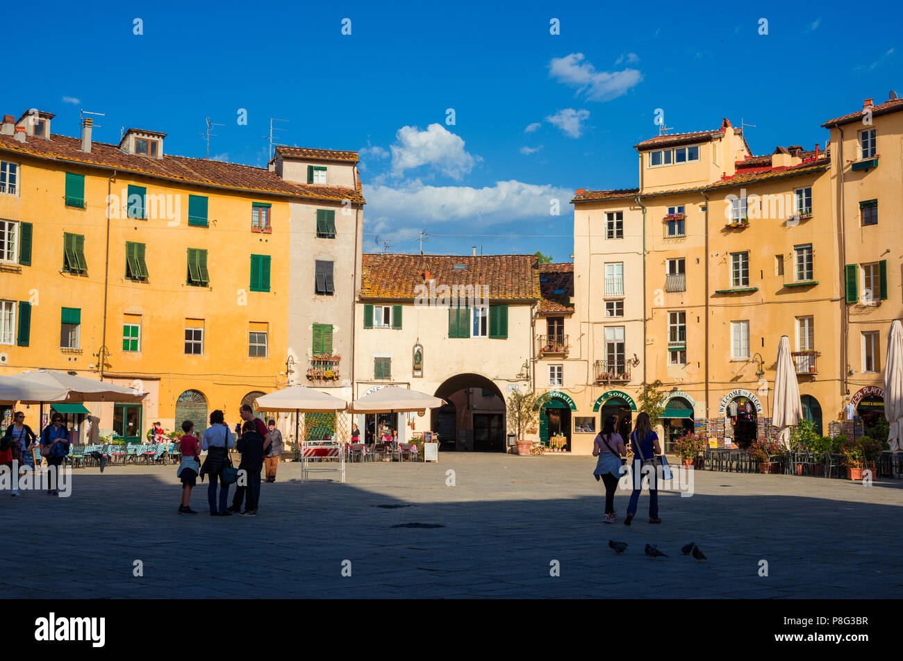 La famosa Piazza dell'Anfiteatro (Piazza Anfiteatro) nel centro storico di Lucca, con le case costruite sull'antica arena romana rovine Foto Stock