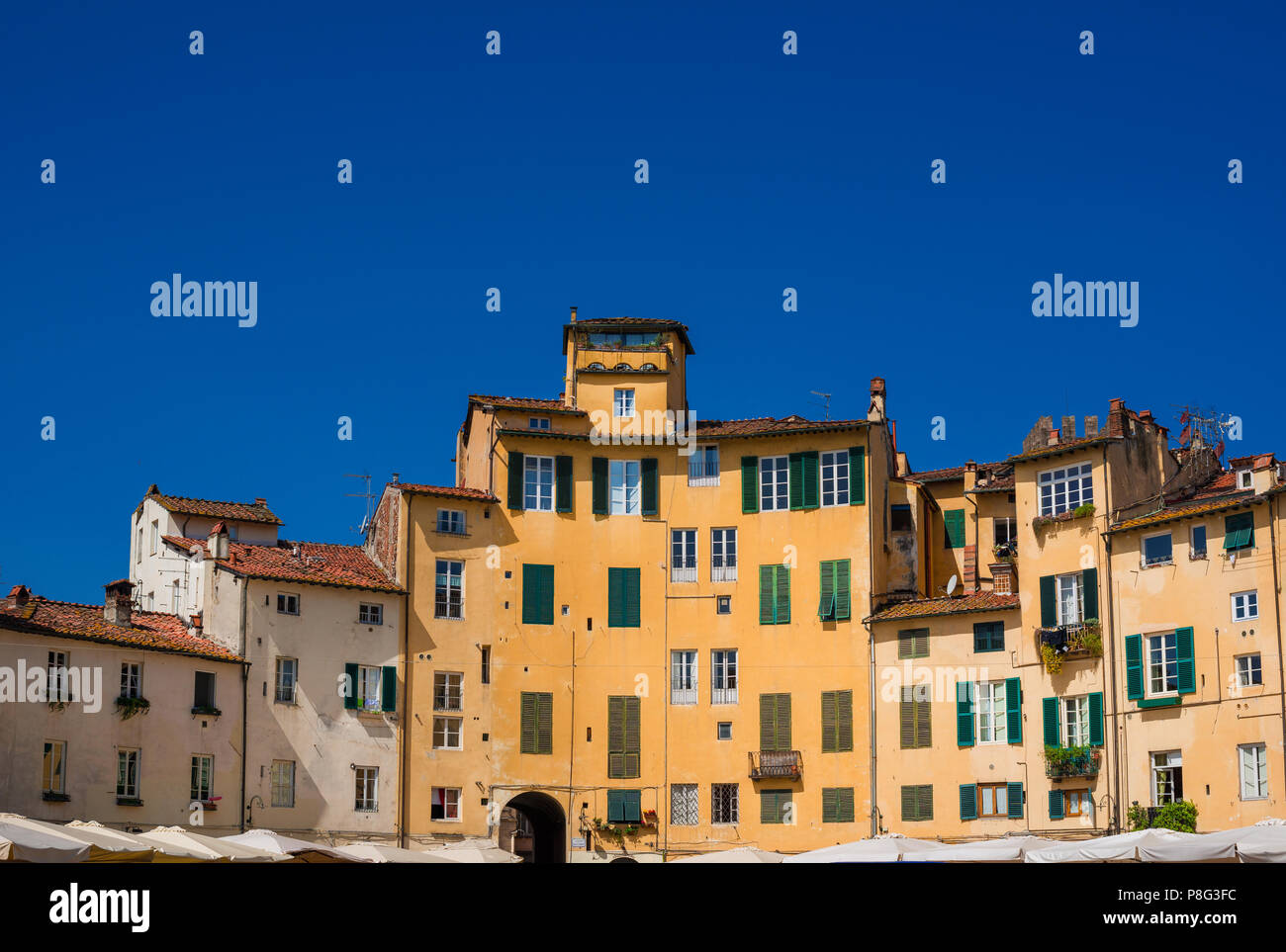 La famosa Piazza dell'Anfiteatro (Piazza Anfiteatro) nel centro storico di Lucca, con le case costruite sull'antica arena romana rovine Foto Stock