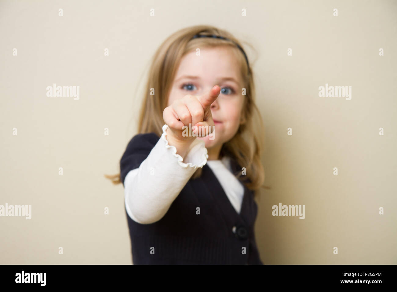 Un giovane bambino tenendo la sua mano rivolta verso l'aria. La messa a fuoco è profondo e centrato sulla mano e sul dito del bambino Foto Stock