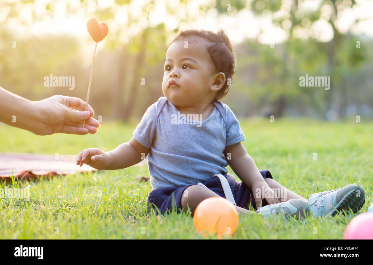 Carino bambino asiatico prendere cuore di madre - Tramonto effetto di filtro Foto Stock