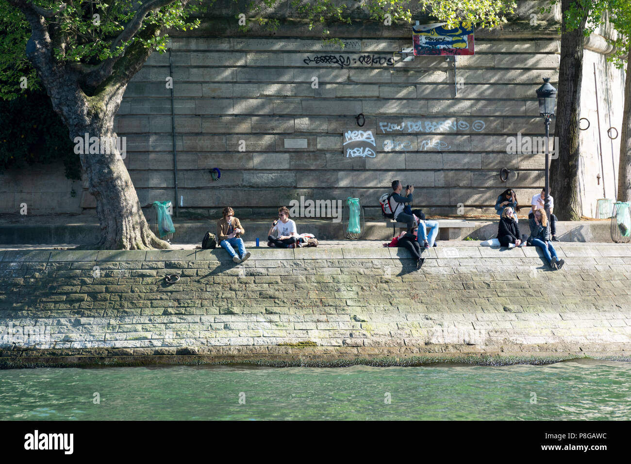 Le persone sono seduti a battuta di un Canal St-Martin a Parigi, Francia. Foto Stock