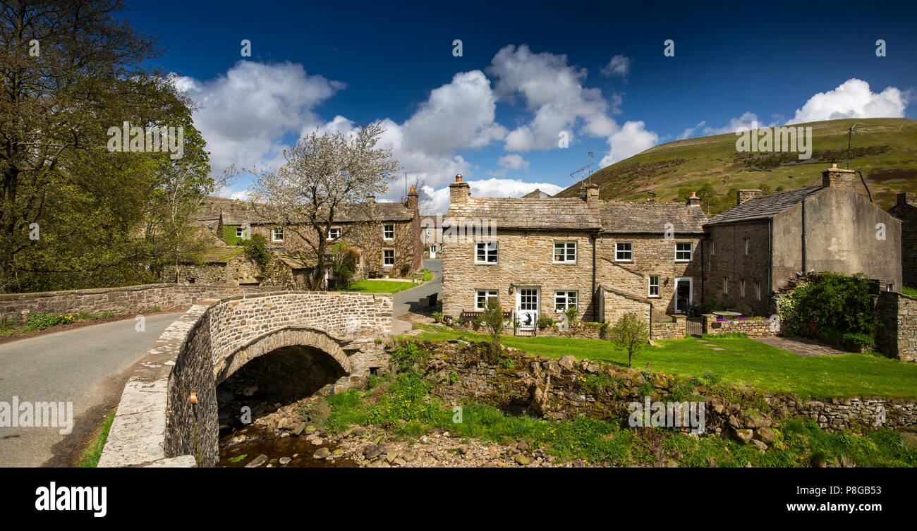Regno Unito, Inghilterra, Yorkshire, Swaledale, Thwaite, case di villaggio attraverso ponte sopra la paglia Beck, panoramica Foto Stock