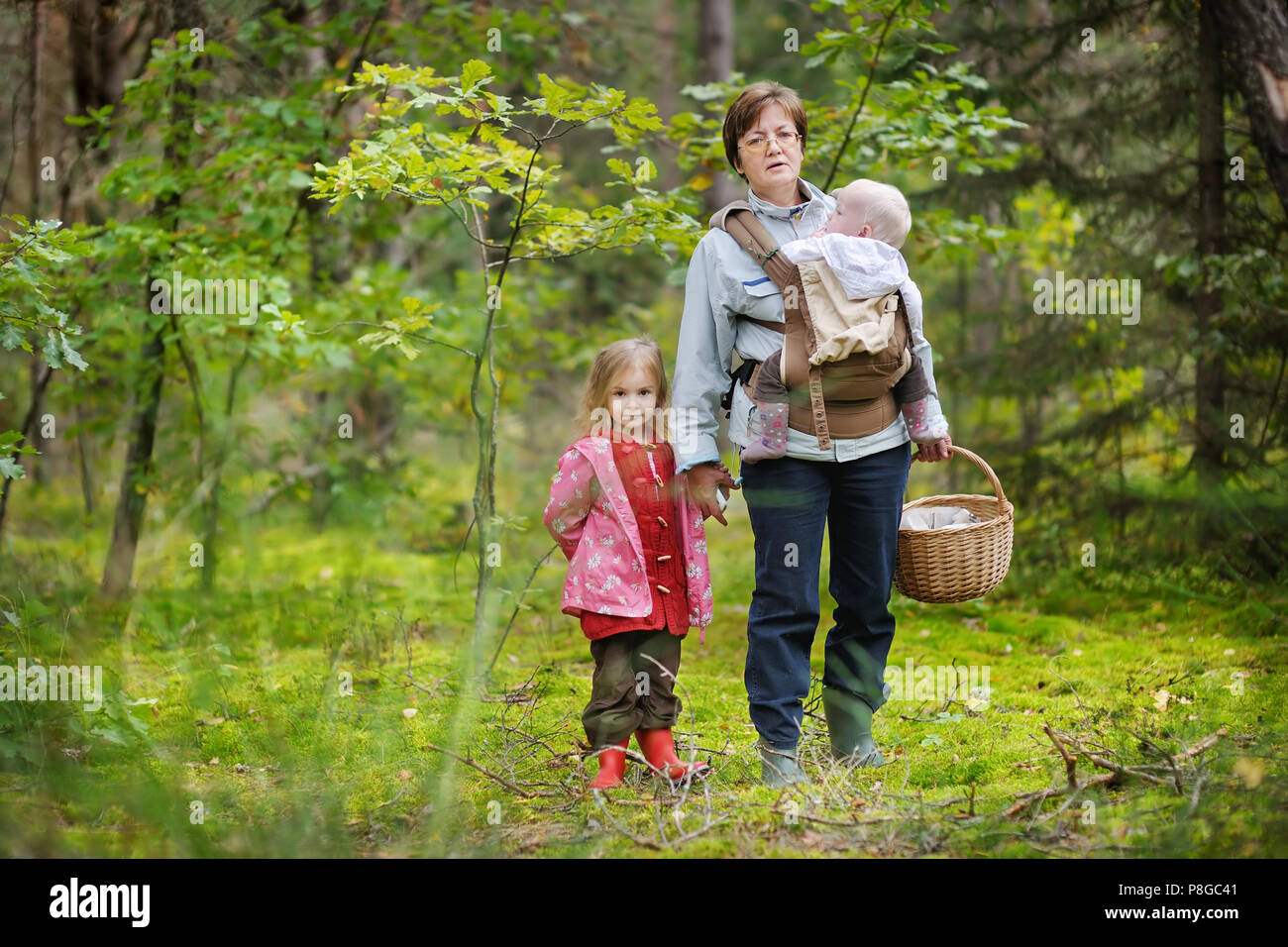 Nonna e la ragazze la raccolta di funghi nella foresta Foto Stock