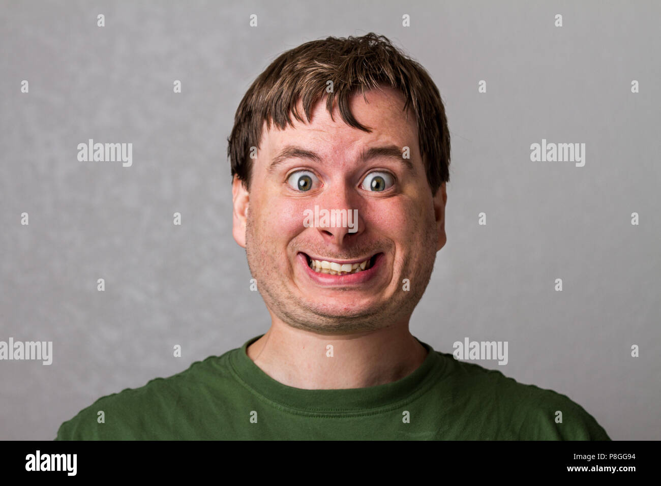 Guy rendendo un inquietante sorriso con una bella testa distorta Foto Stock