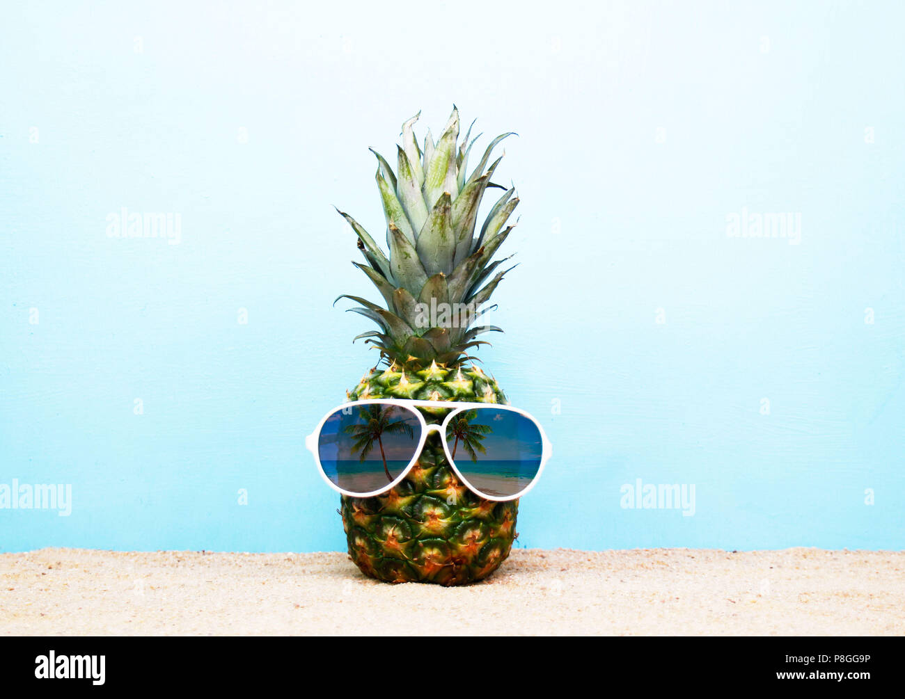 Tropical idee di viaggio, un ananas indossando occhiali da sole sulla spiaggia Foto Stock