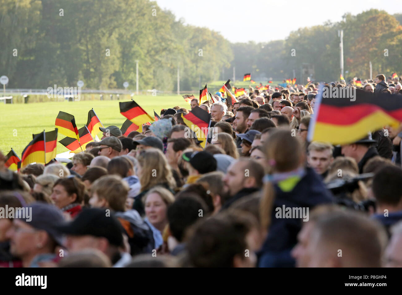 Hoppegarten, Germania, persone wave bandiere nazionali il giorno dell'unificazione tedesca Foto Stock