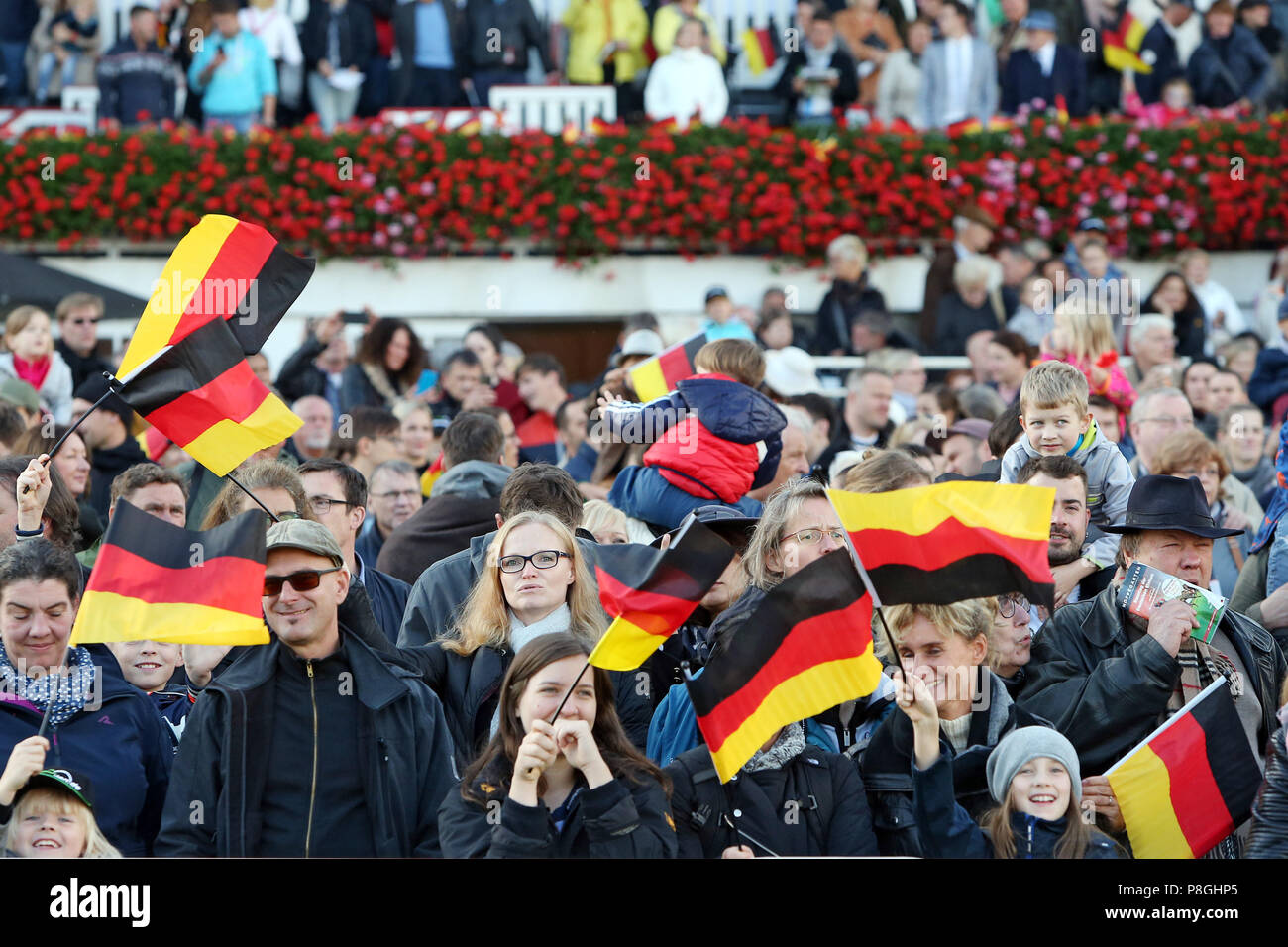 Hoppegarten, Germania, persone wave bandiere nazionali il giorno dell'unificazione tedesca Foto Stock