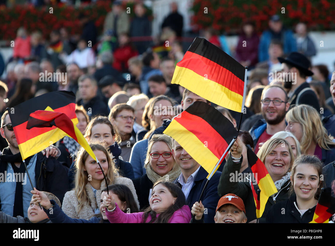 Hoppegarten, Germania, persone wave bandiere nazionali il giorno dell'unificazione tedesca Foto Stock
