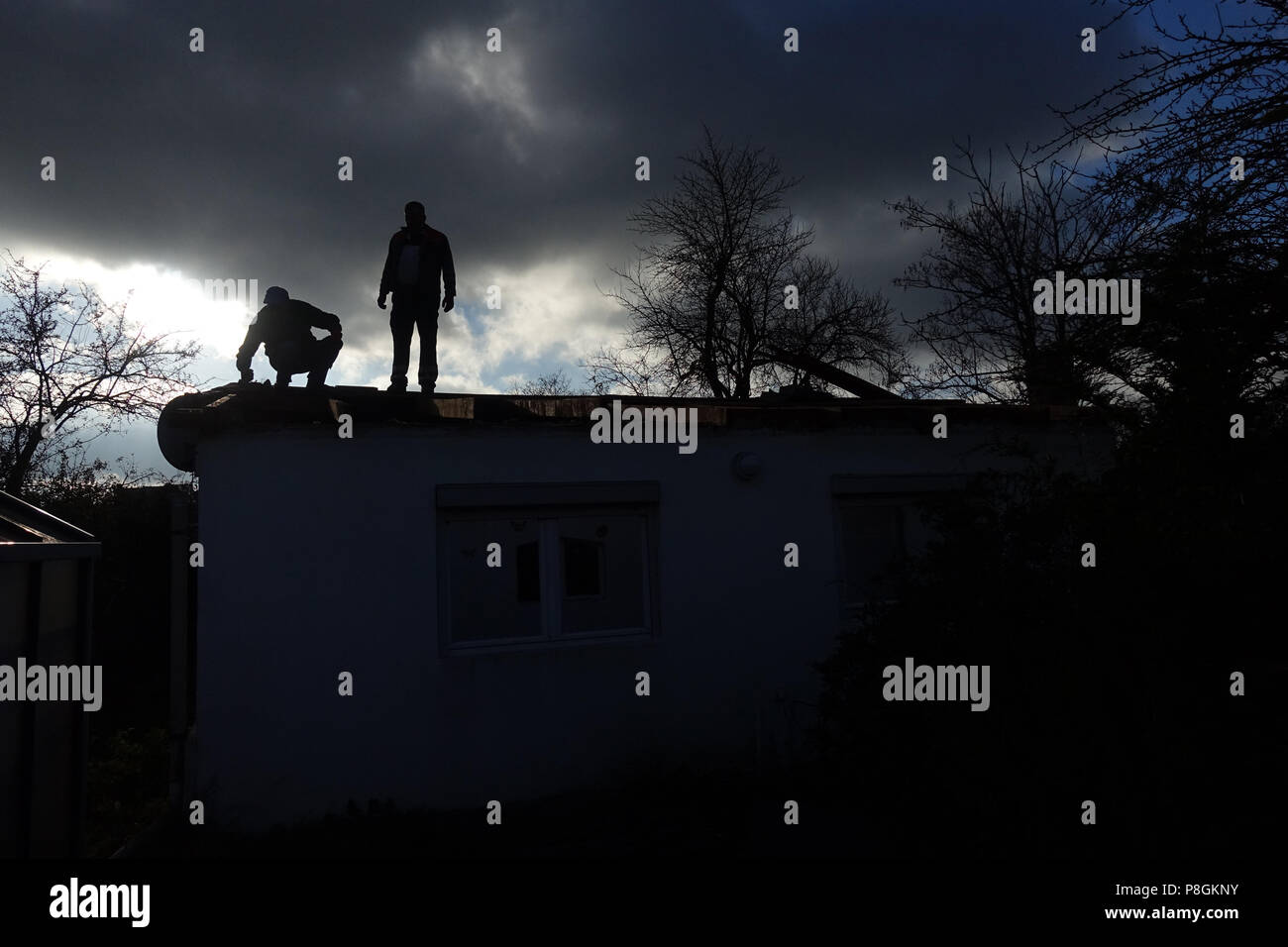 Berlino, Germania, Silhouette, artigiano in piedi sul tetto di un gazebo Foto Stock