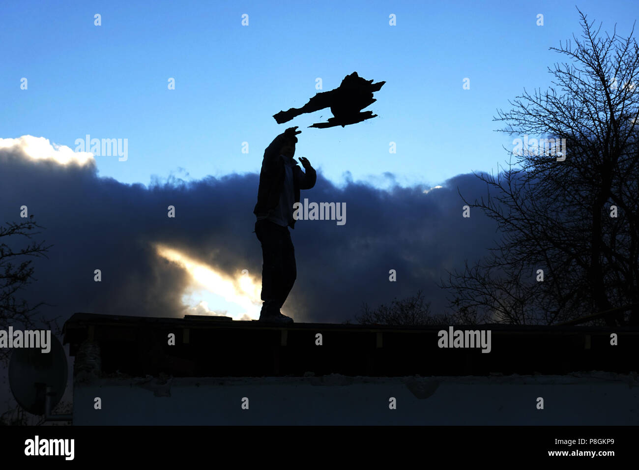 Berlino, Germania, Silhouette, artigiano getta bitumati dal tetto di un gazebo Foto Stock