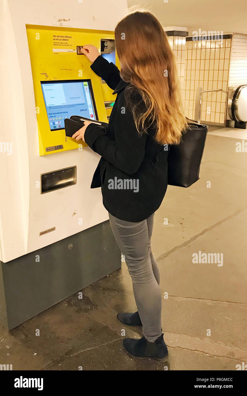 Berlino, Germania, giovane donna acquista un biglietto presso un distributore automatico di LPP Foto Stock