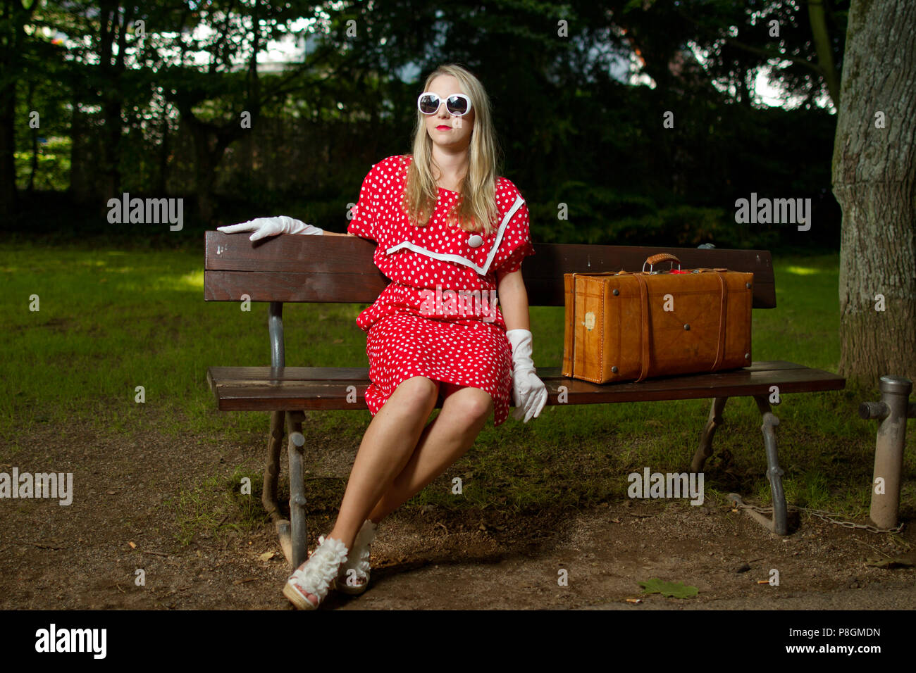Retro vintage anni sessanta anni settanta anni ottanta giovane ragazza bionda in abito rosso vecchio Foto Stock