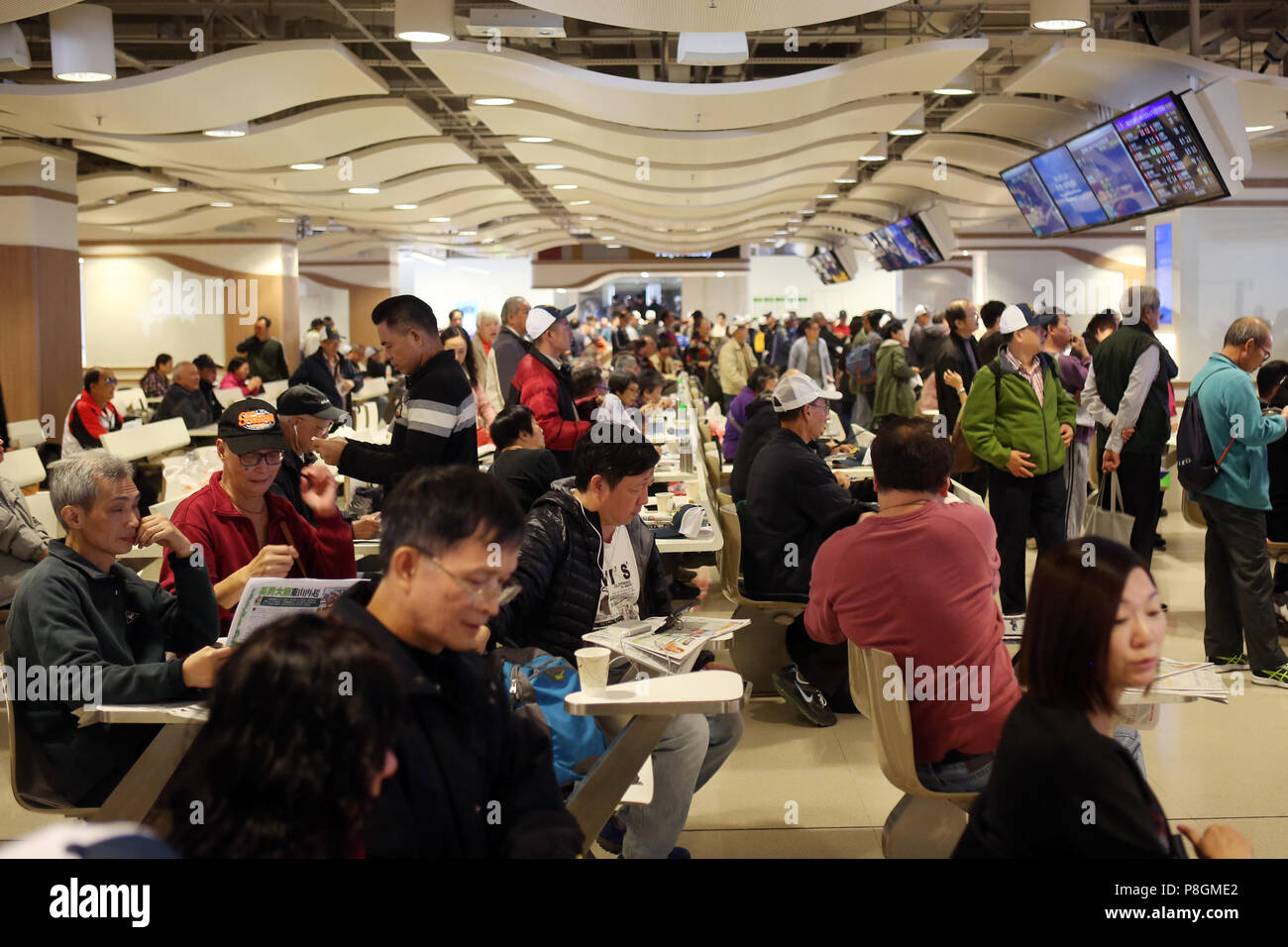 Hong Kong, Cina, persone in una sala scommesse dell ippodromo Sha Tin Foto Stock