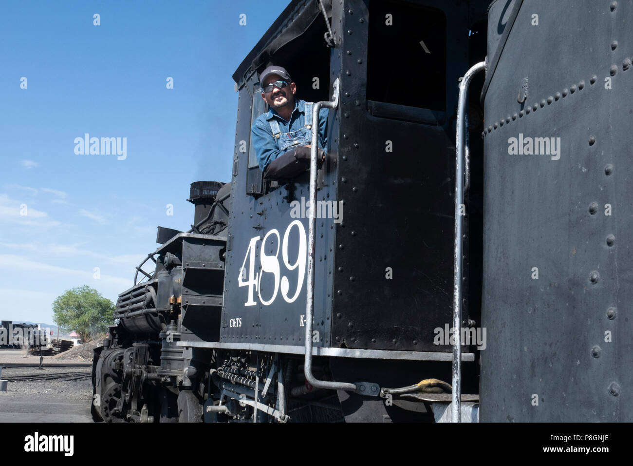 Ritratto di un treno ingegnere sul Cumbres e Toltec Scenic Railroad in posa con il restaurato motore di vapore 489, un K-39 mikado locomotiva classe Foto Stock