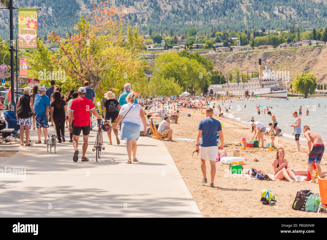 Penticton, British Columbia, Canada - Luglio 7, 2018: i turisti e la gente del posto a piedi lungo la sponda del lago e godervi la spiaggia sul lago Okanagan su una calda estate d Foto Stock