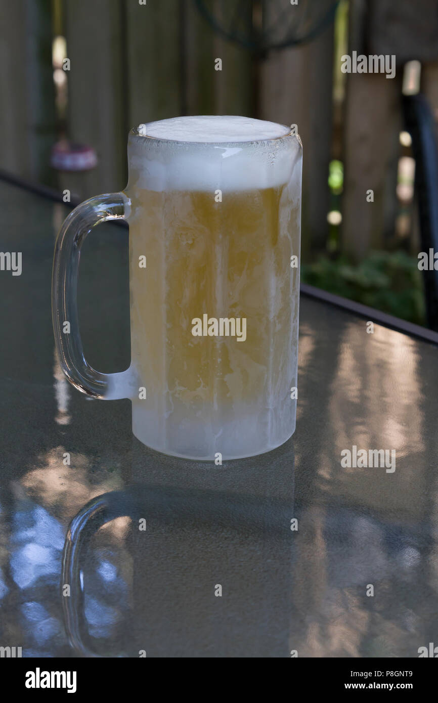 Un pupazzo di neve con la tazza di birra su di un tavolo di vetro Foto Stock