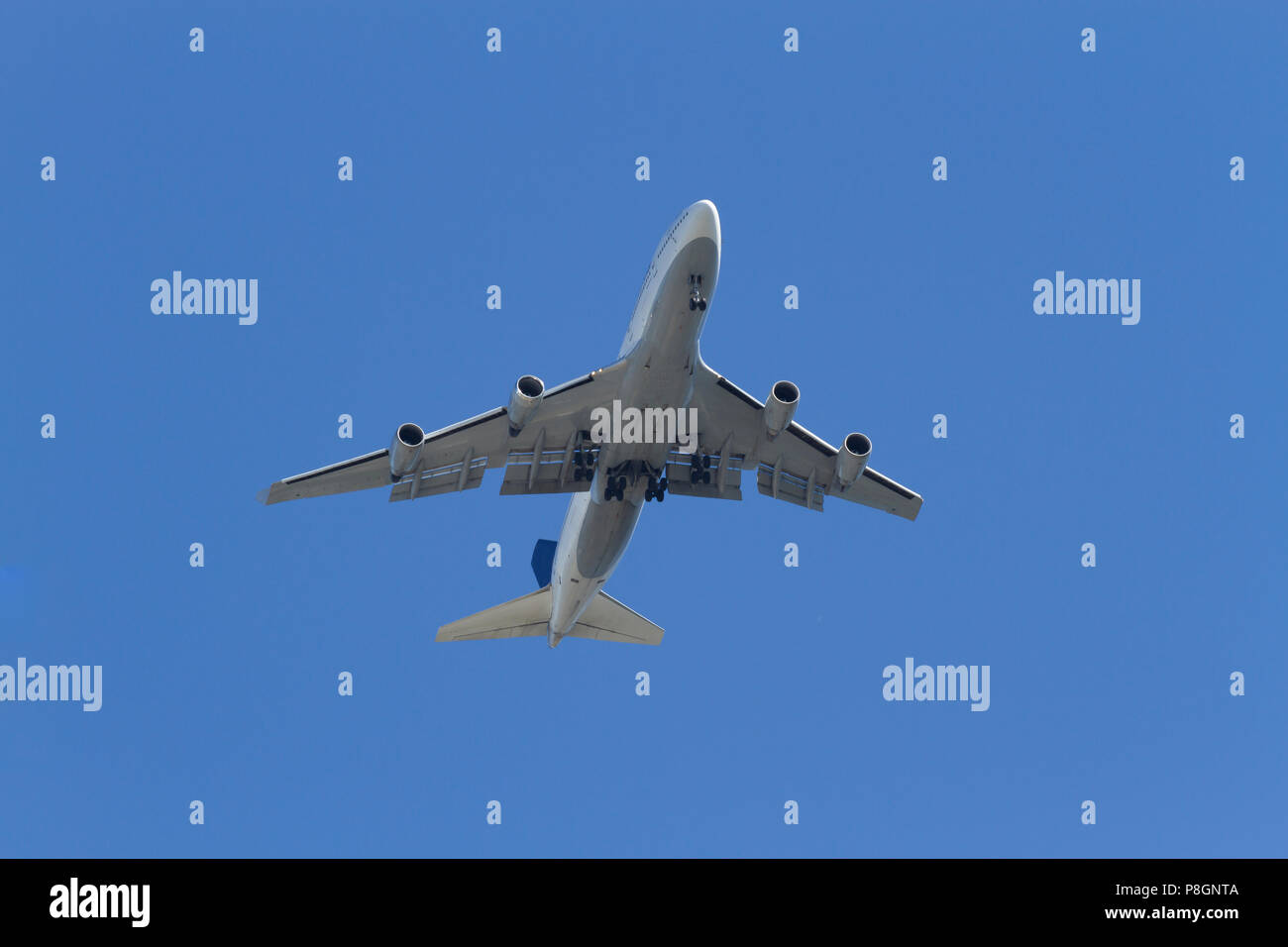 Vista dal basso di un aereo passeggeri con il carrello di atterraggio verso il basso Foto Stock
