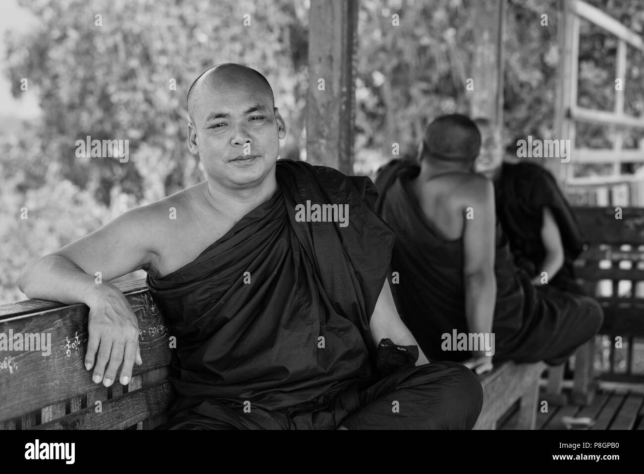I MONACI BIRMANI utilizza il teak U BEINS ponte per commutare tra il Lago Taungthaman presso sunrise - AMARAPURA, MYANMAR Foto Stock