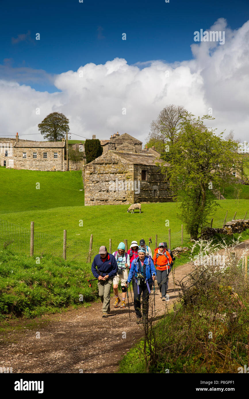 Regno Unito, Inghilterra, Yorkshire, Swaledale, Keld, Myers fondo, gruppo di escursionisti campo passando fienile con 1687 architrave in pietra Foto Stock