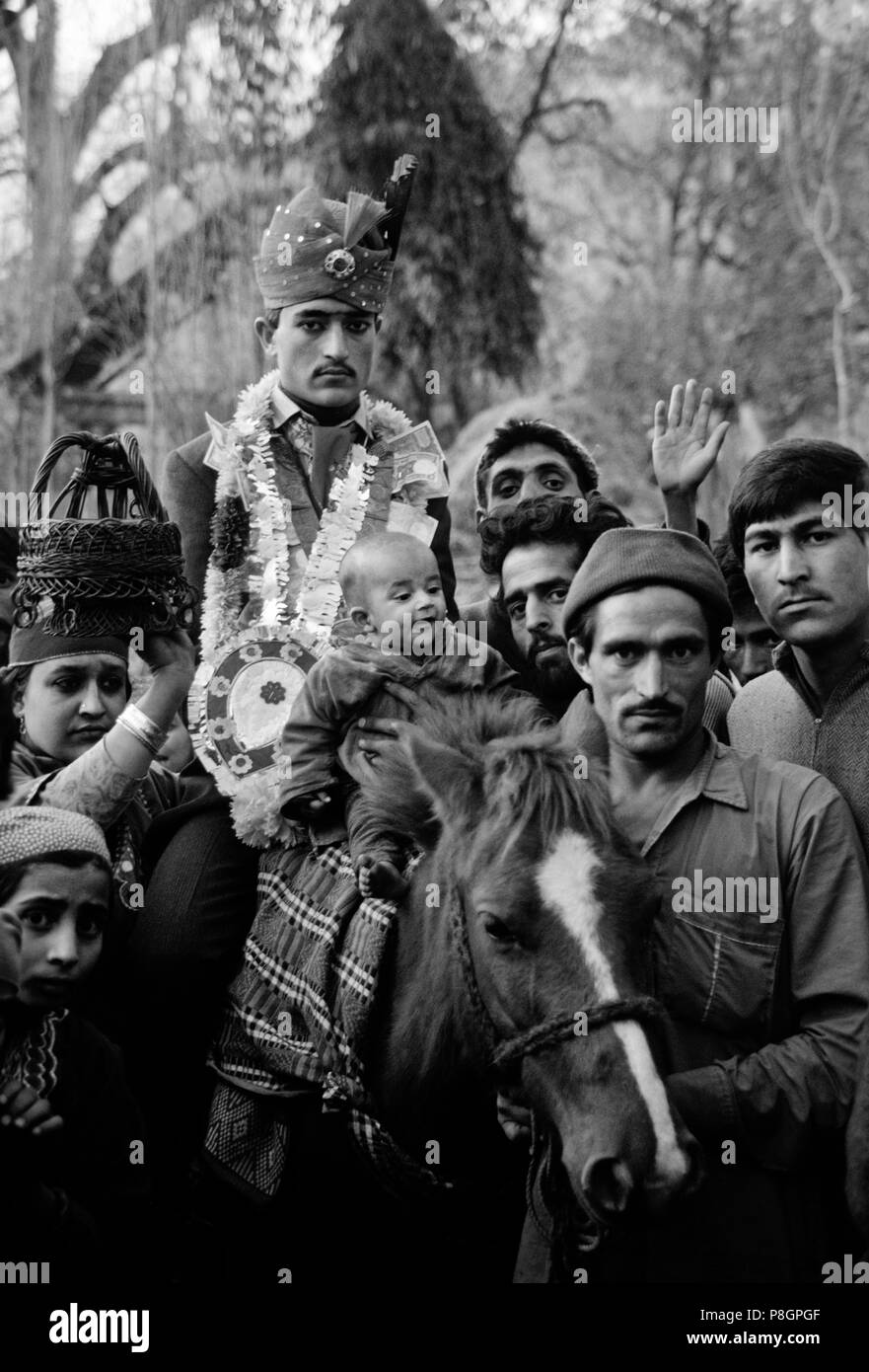 Costume GROOM passeggiate a cavallo alla sua brides domestici in AFAN VILLAGE durante il suo matrimonio - KASHMIR INDIA Foto Stock