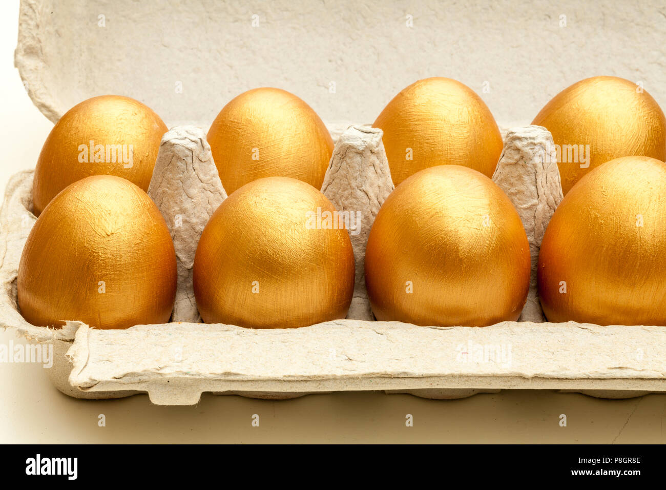 Dipinte a mano uova d'oro in una confezione di uova Foto Stock
