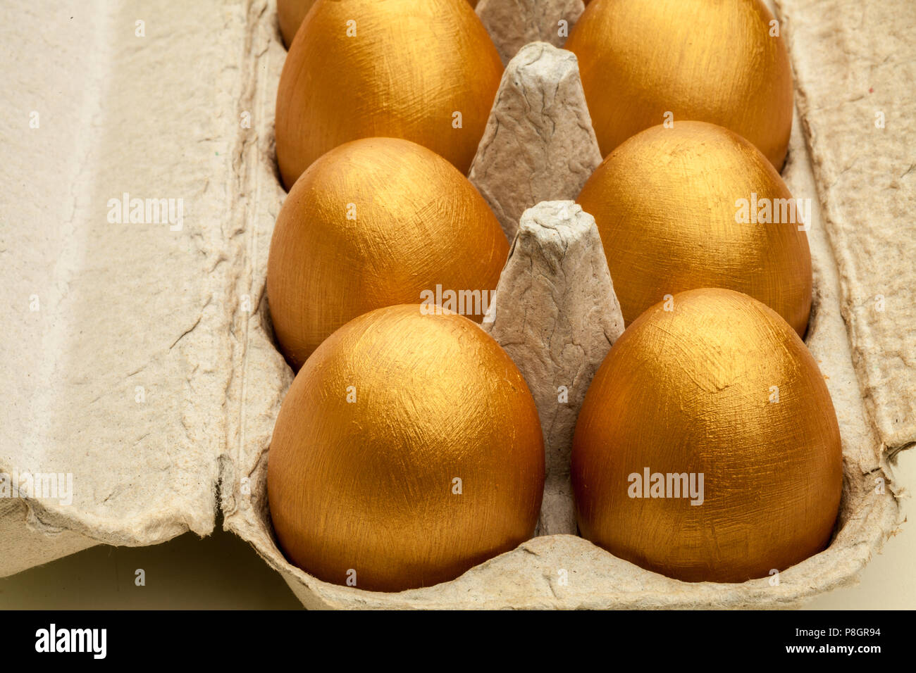 Dipinte a mano uova d'oro in una confezione di uova Foto Stock