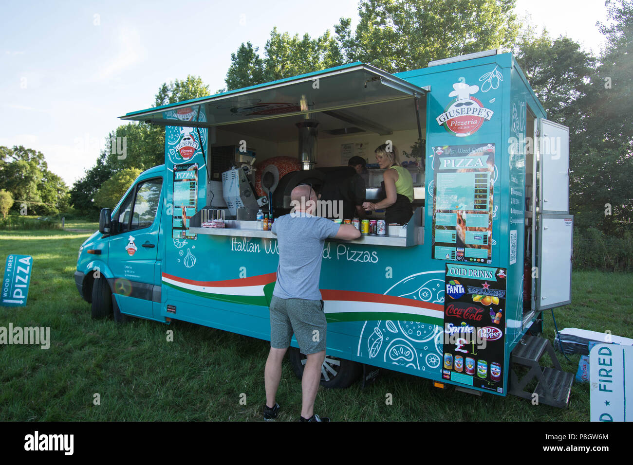 Un cliente ordina dal furgone italiano per pizza a legna di Giuseppe a un incontro di auto classiche con il furgone da asporto Earls Barton Northamptonshire UK Foto Stock