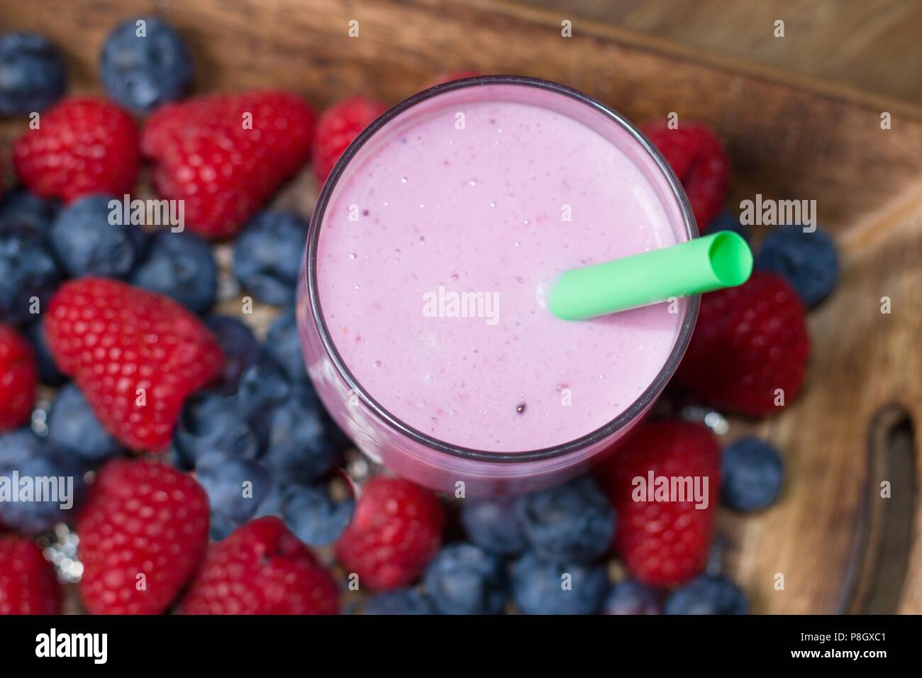 Estate sano ristoro. Milky mirtillo e lampone agitare direttamente dall'alto Foto Stock