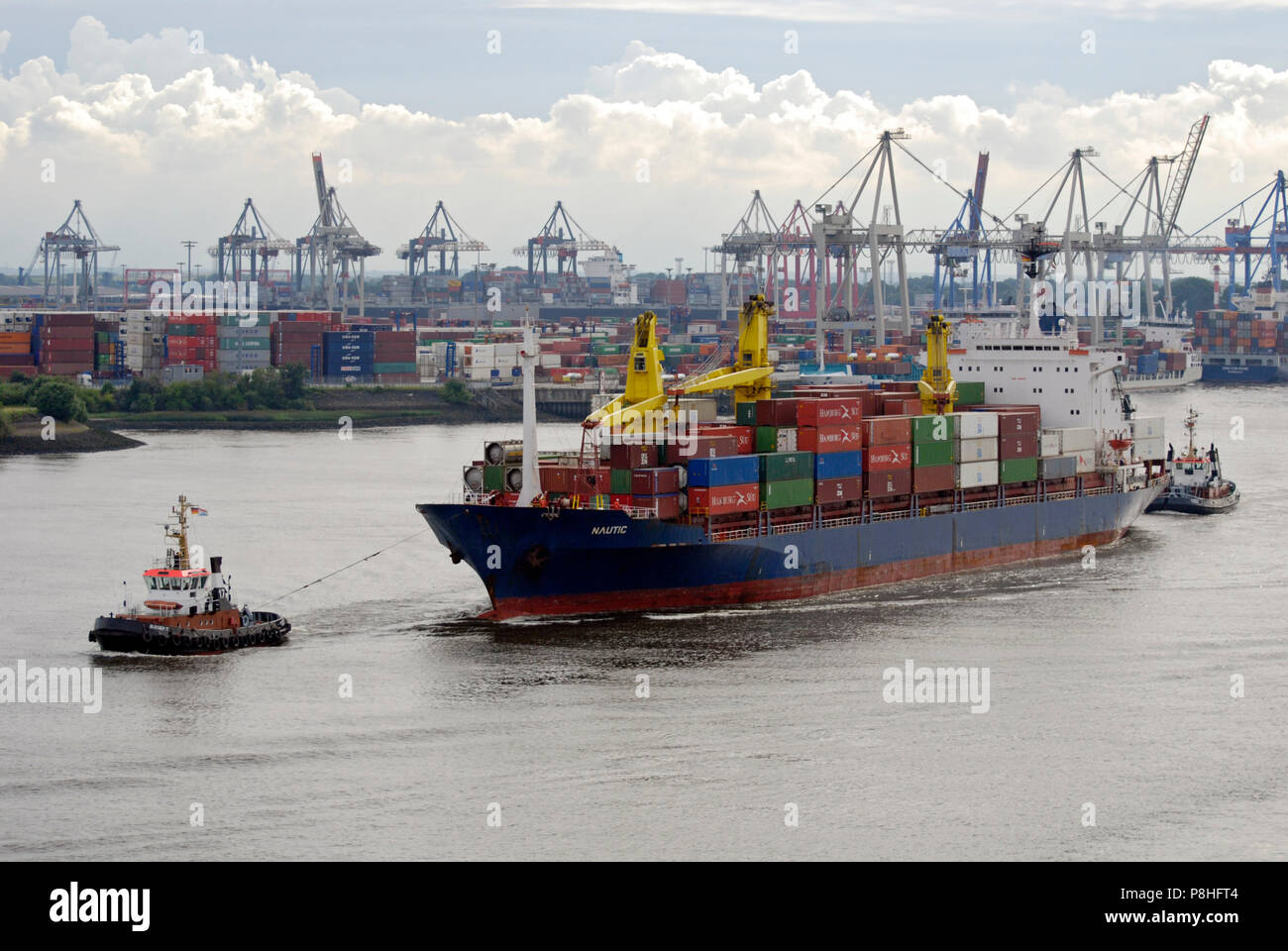 Zwei manoevrieren Schlepper auf der Elbe einen Container-Frachter in der Hamburger Hafen. Im Hintergrund die Container-Terminals Eurogate und Burchard Foto Stock