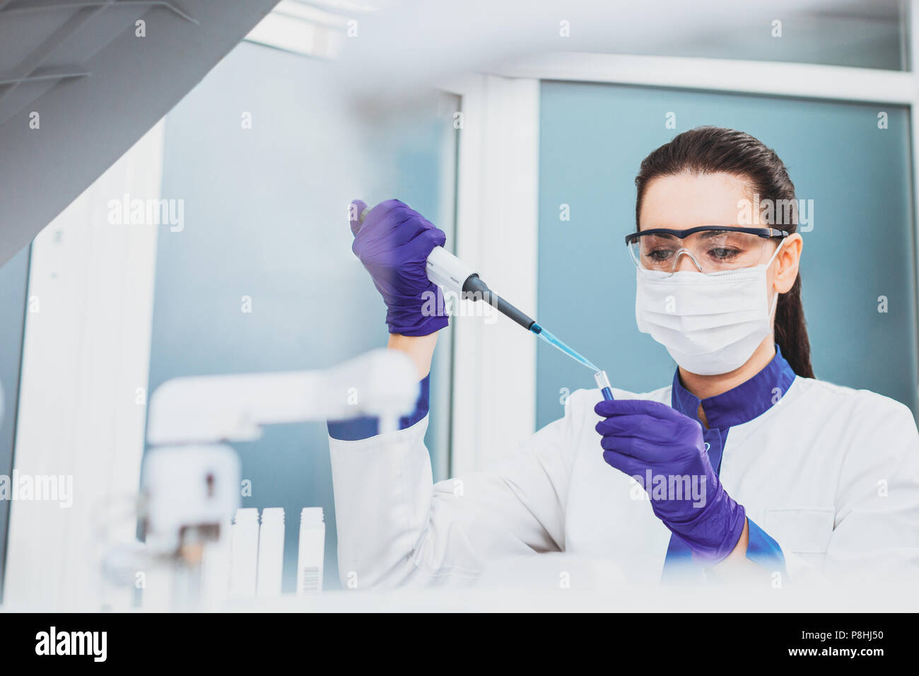 Concentrato curante tenendo campione dalla provetta Foto Stock