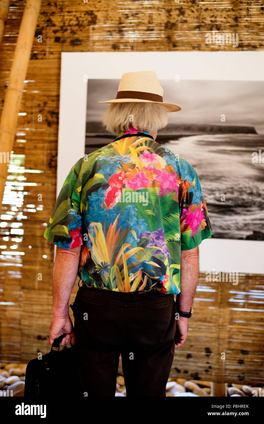 Arles, Francia. Un uomo che indossa un cappello di paglia e maglietta colorata nel pop up bamboo pavilion con "contemplazione' , una mostra del buddismo Foto Stock