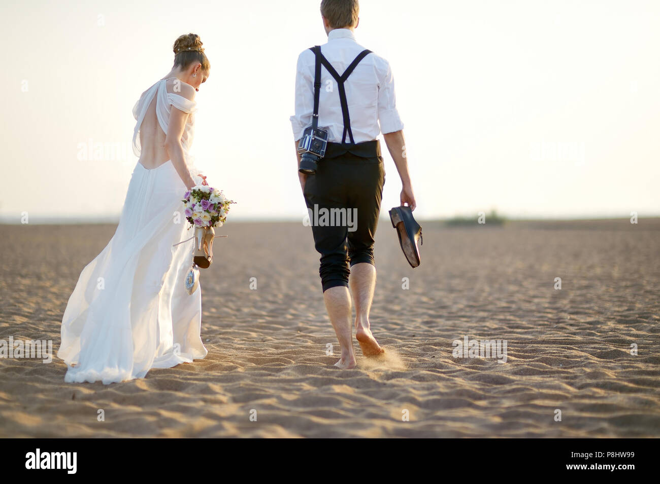 Felice sposa e lo sposo su una bellissima spiaggia sul tramonto Foto Stock