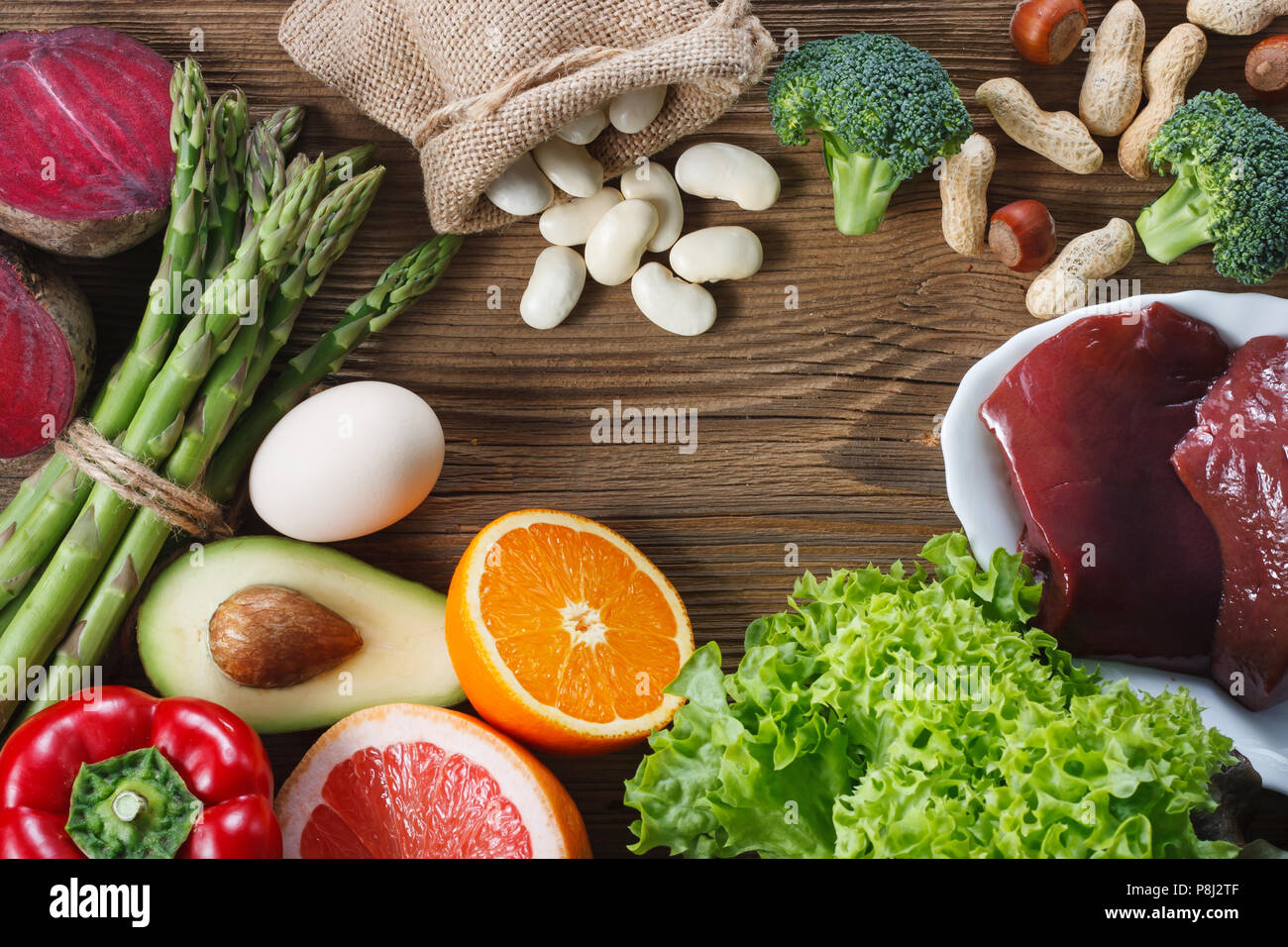 Fonti naturali di acido folico come fegato, asparagi, broccoli, uova, insalata di avocado, paprica, dadi, arancione , barbabietole e fagioli Foto Stock