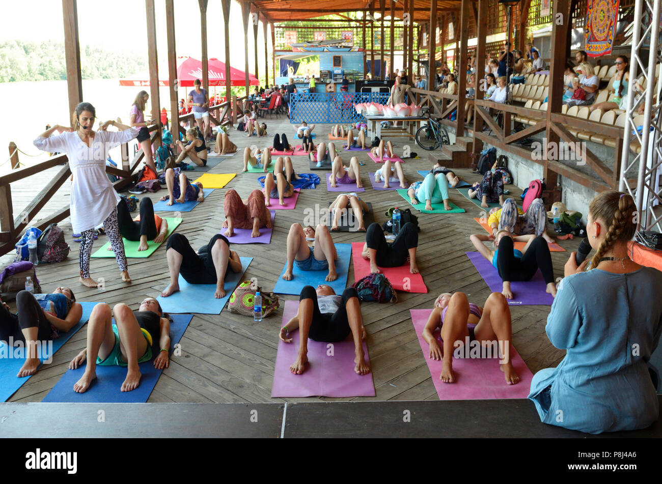 Persone che praticano lo Yoga pone durante il festival di Yoga e cultura vedica "Vedalife-2017, Isola". Il 7 agosto 2017. Kiev, Ucraina. Foto Stock