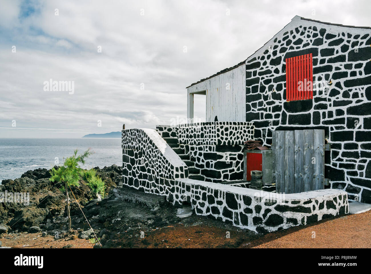 Una casa tradizionale realizzato con scure rocce vulcaniche in un villaggio sull isola Pico, Azzorre, Portogallo. Foto Stock