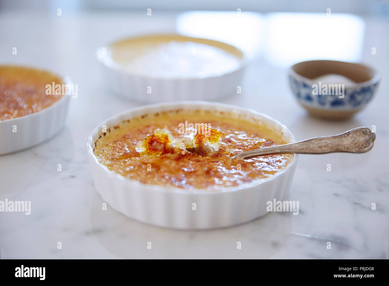 Close up incrinato brûlée crema con cucchiaino Foto Stock