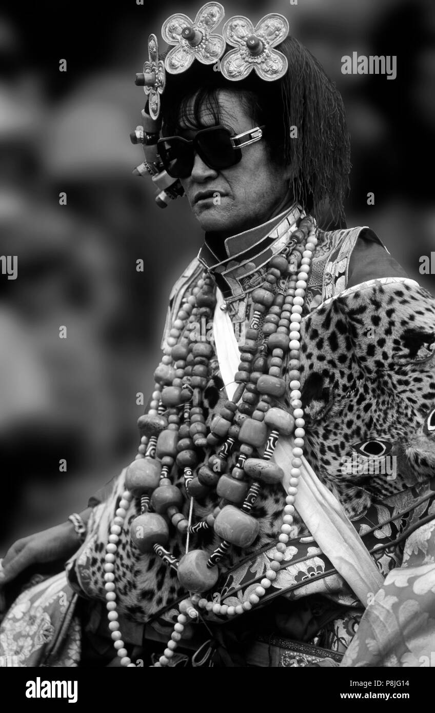 Khampa maschio indossa a pelle di leopardo, corallo, zee pietre e oro gau caselle all'Litang Horse Festival - Provincia di Sichuan, in Cina (Tibet) Foto Stock