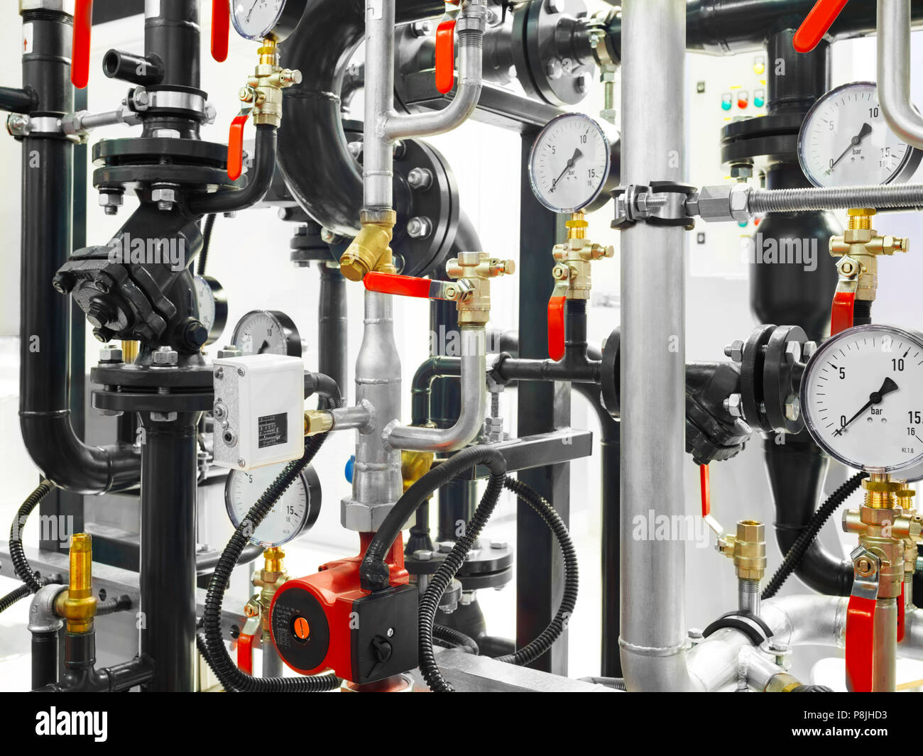Chiusura del manometro, tubo, misuratore di flusso acqua pompe e valvole del sistema di riscaldamento in un locale caldaia Foto Stock