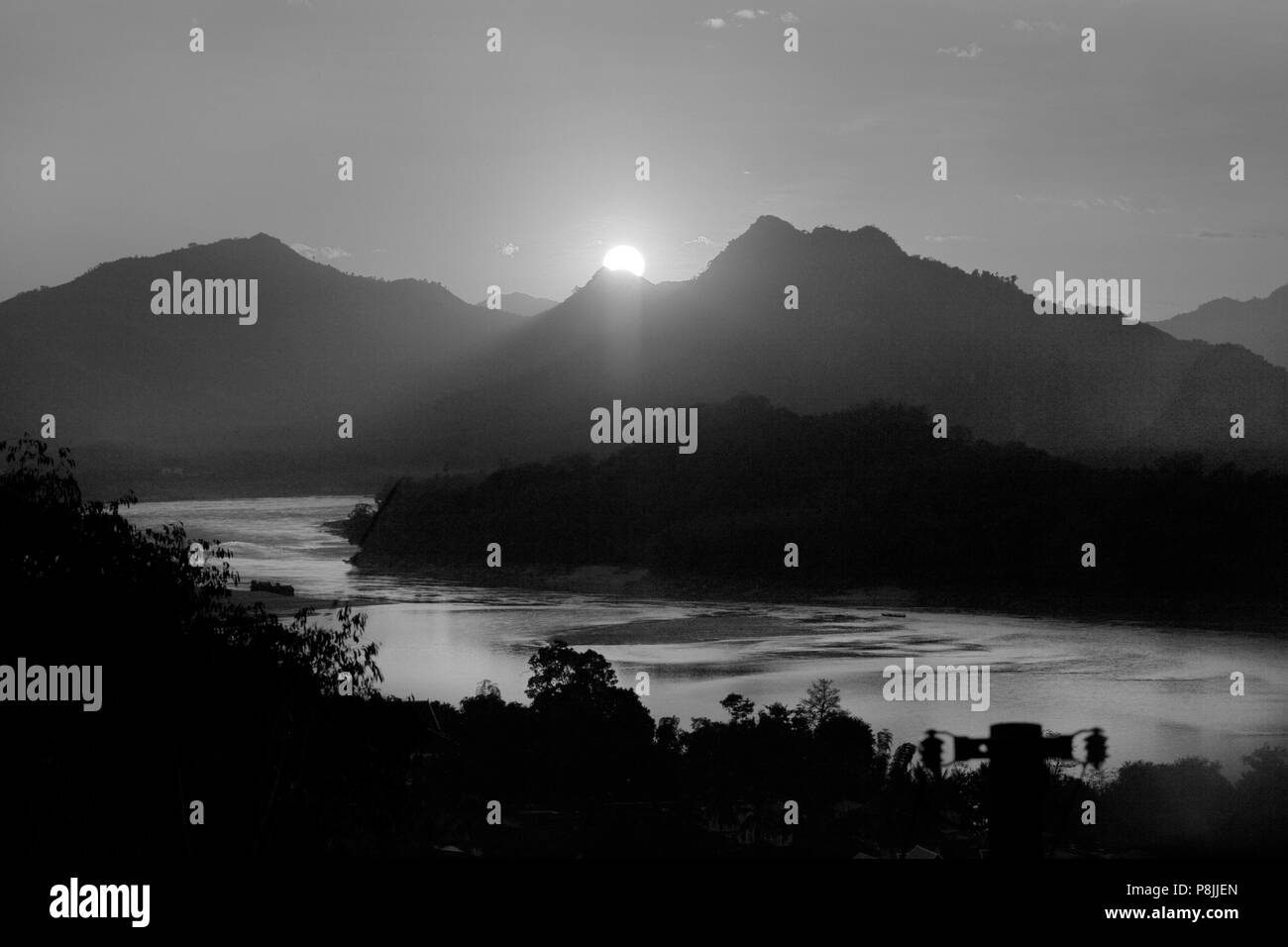 Il sole tramonta su una collina sul fiume Mekong nella ex Provinciale città di Luang Probang - Laos Foto Stock