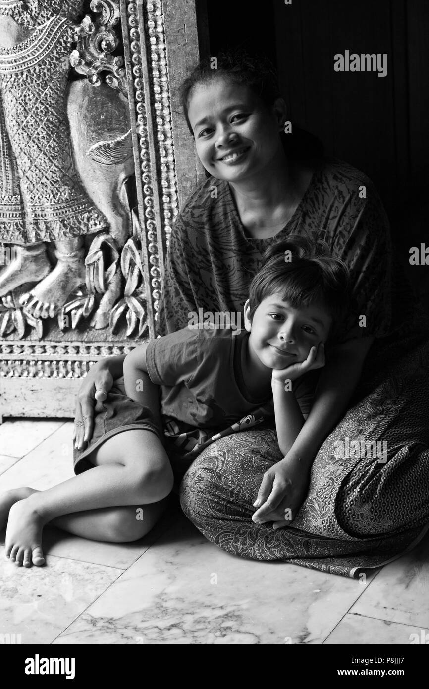 THAI madre e bambino dentro il buddista di Wat Xieng Thong (il Tempio della città d'Oro), costruito nel 1560 - Luang Probang, LAOS Foto Stock