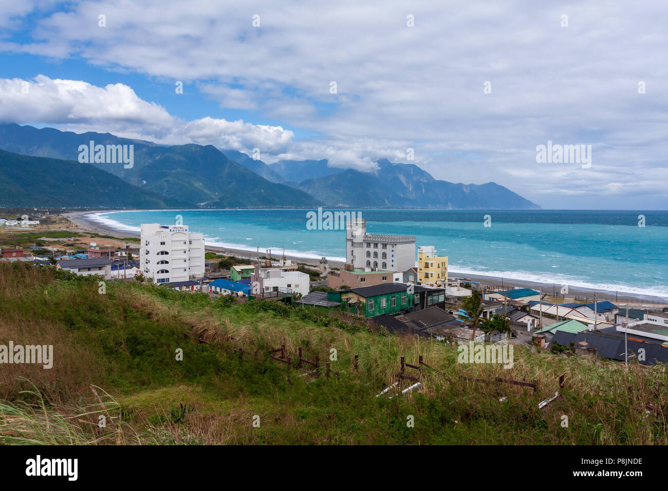 Chisingtan Scenic Area, baia con acque azzurre oceanside vista, Catena Montuosa Centrale con poco nuvoloso cielo blu in background, Hualien, Taiwan Foto Stock