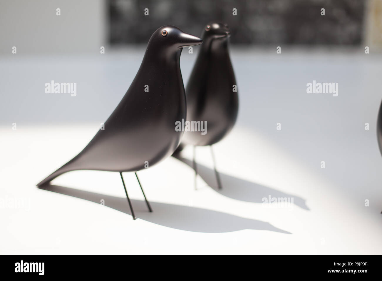Un paio di Eames House Bird nero, classica versione laccata nera, collezione di accessori Vitra in mostra. Foto Stock