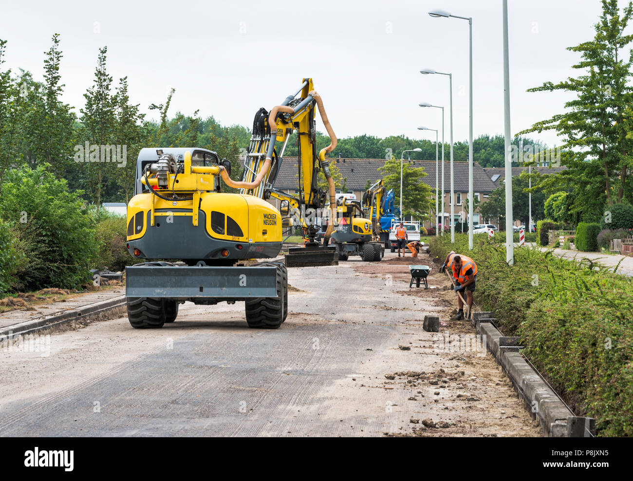 Hellevoetlsuis,Olanda-12-luglio-2018:costruzione i lavoratori sono occupati n rinnovo la strada nel villaggio,uno in un bianco le strade hanno per ottenere nuovo asfalto e verrà chiuso per diverse settimane Foto Stock