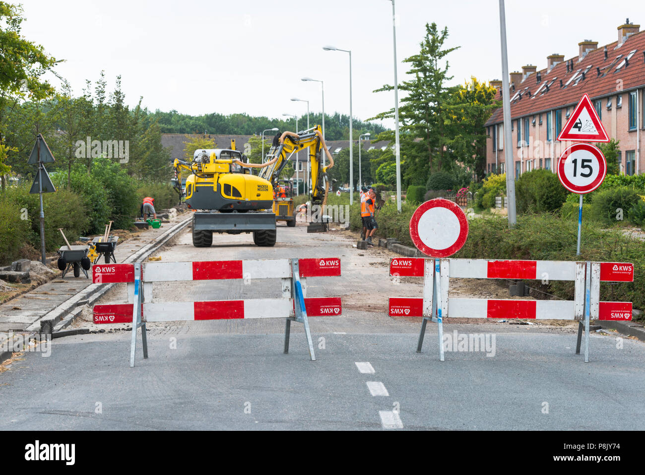 Hellevoetlsuis,Olanda-12-luglio-2018:costruzione i lavoratori sono occupati nel rinnovare la strada nel villaggio,uno in un bianco le strade hanno per ottenere nuovo asfalto e verrà bloccata Foto Stock