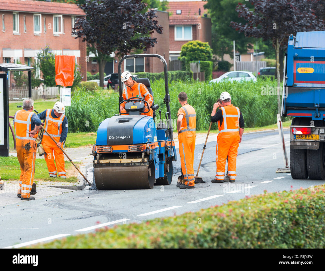 Hellevoetlsuis,Olanda-12-luglio-2018:costruzione i lavoratori sono occupati nel rinnovare la strada nel villaggio,uno in un bianco le strade hanno per ottenere nuovo asfalto e verrà chiuso per diverse settimane Foto Stock